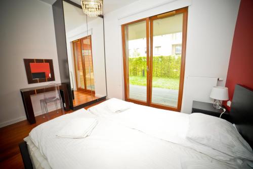 グディニャにあるLily Apartment Orłowo - Hav Apartsの窓付きの客室の白いベッド1台