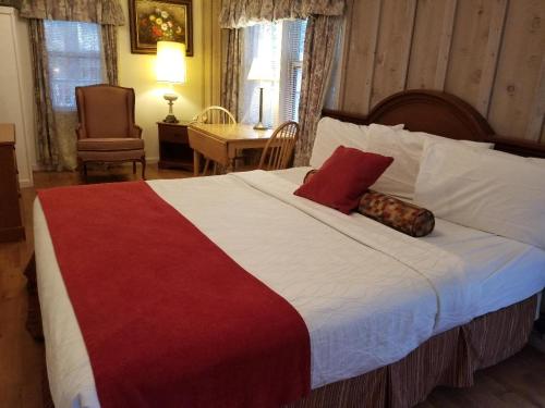 a bedroom with a large bed with a red and white blanket at Nevada City Inn in Nevada City