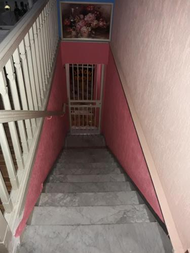 a stairway with a red wall and a stair case at Hotel bom retiro in Sao Paulo