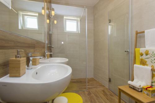 a bathroom with a white sink and a shower at Dalmatian stone Villa Burica in Vinišće