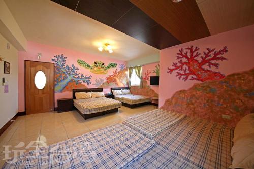 綠島鄉的住宿－綠島微風民宿 ，卧室墙上有绘画作品