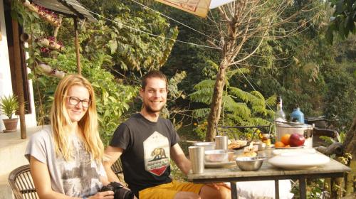 un uomo e una donna seduti a un tavolo di Peace Guest House a Pokhara