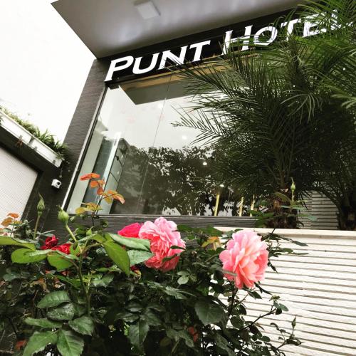 a bunch of pink roses in front of a pink hotel at Punt Hotel in Hai Phong