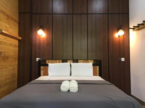 a bedroom with a bed with two white shoes on it at Villa Eden Paradise in Ella