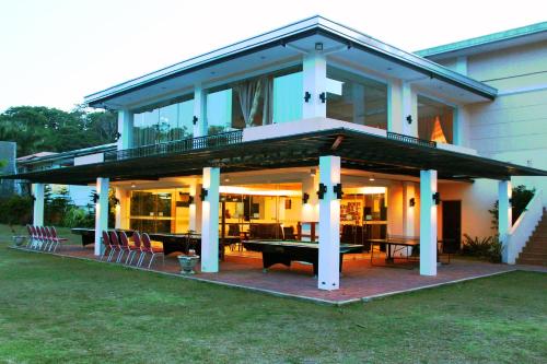 a house with a deck with a ping pong table at Forest Crest Nature Hotel and Resort Powered by ASTON in Nasugbu