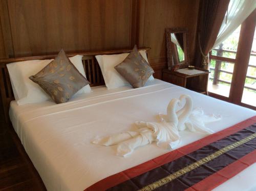 una cama con dos cisnes hechos de toallas en Lanta Wanida Resort, en Ko Lanta