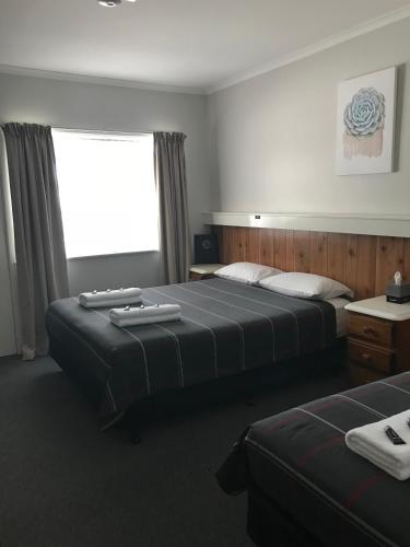 a hotel room with two beds and a window at Glenrowan Kelly Country Motel in Glenrowan