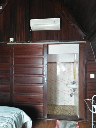 a room with a bed and a bathroom with a sink at Rama Homestay in Nusa Penida