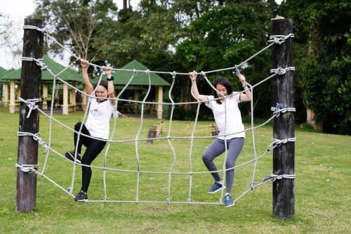two girls jumping on a net in a park at Forest Crest Nature Hotel and Resort Powered by ASTON in Nasugbu