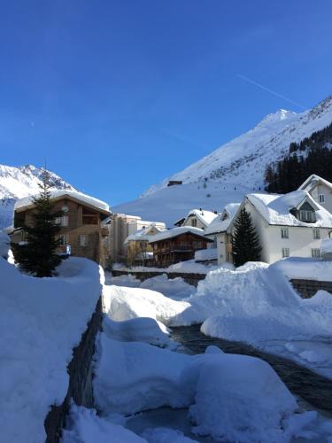 a village covered in snow with a river at Alpenhotel Schlüssel in Andermatt