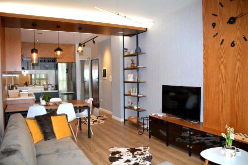 Una sala de estar con un sofá y un comedor. en Central Luxury Apartment, en Tirana