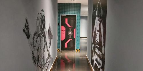 a hallway with a door with graffiti on the walls at Space Hotel @ Chinatown Kuala Lumpur in Kuala Lumpur
