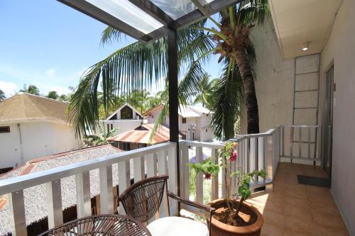 a balcony with chairs and a palm tree at MR Holidays Hotel in Boracay