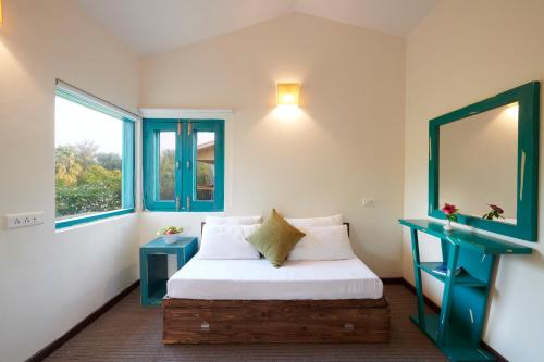 a bedroom with a bed and two windows at Aacorn Hideaway Resort & Spa in Rāmnagar