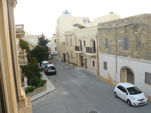 a view of a street with cars parked on the road at Acomodation House Kavarna in Xagħra