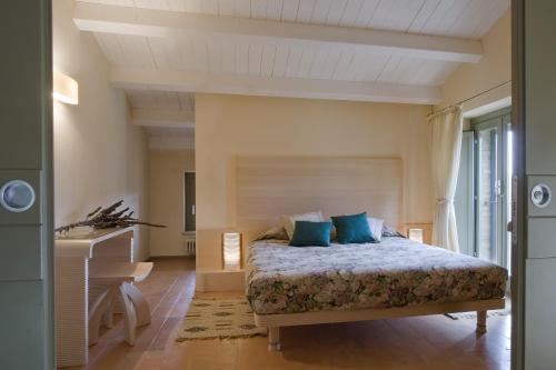カステルヌオーヴォ・ベラルデンガにあるLa Capanna di Castell'in Villaのベッドルーム(青い枕のベッド1台付)