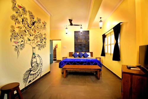 1 dormitorio con 1 cama y una pintura en la pared en Oolala - Your lake house in the center of Udaipur, en Udaipur