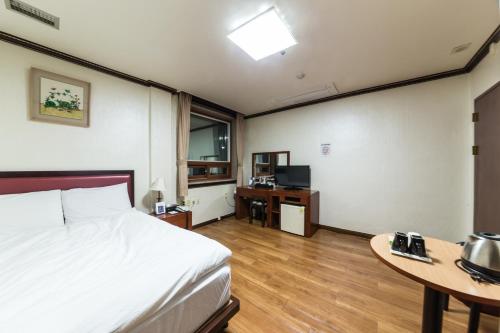 a hotel room with a bed and a desk and a table at Youngbin Hotel in Seoul