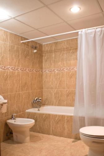 a bathroom with a tub and a toilet and a sink at Hotel San Martin in Altafulla