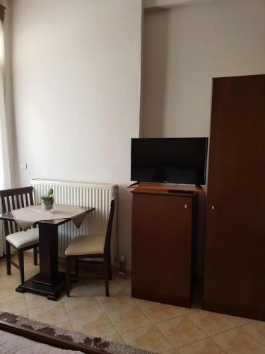 a dining room with a table and a tv on a cabinet at Xenonas Arxontiko in Kato Loutraki