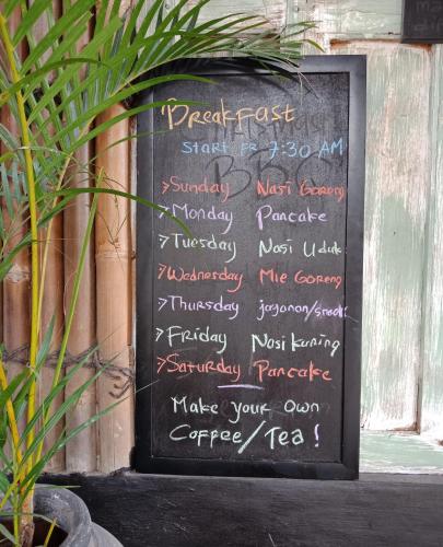a chalkboard with a menu on a wall at Arjuna Garden Homestay in Yogyakarta