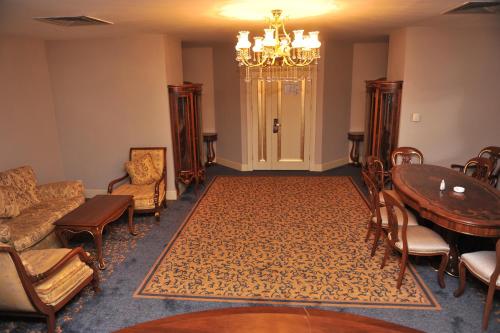 a waiting room with a table and chairs and a chandelier at Hotel Intourist Palace Batumi in Batumi