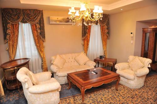 a living room with furniture and a chandelier at Hotel Intourist Palace Batumi in Batumi