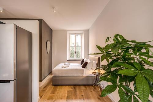 ローマにあるSant'eiligio loft campo di fioriのベッドルーム(ベッド1台、鉢植えの植物付)