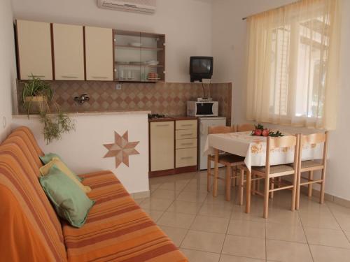 a living room with a table and a kitchen at Apartments Oaza Regi in Medulin