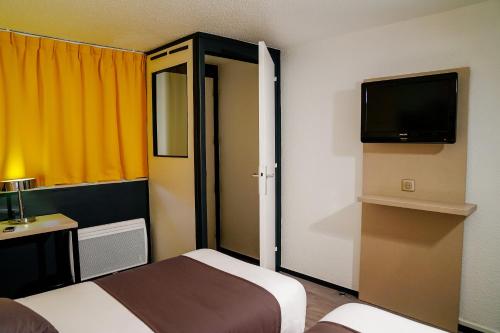 a hotel room with two beds and a tv at Kyriad Lille - Roncq in Roncq