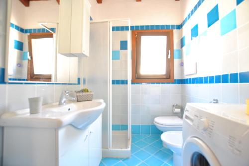 a blue and white bathroom with a sink and a toilet at COUNTRY HOUSE HOLIDAY - Olbia in Olbia