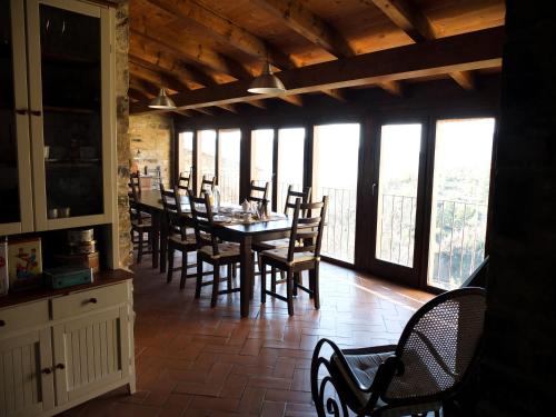 a dining room with a table and chairs and windows at O Chardinet d'a Formiga in Aínsa