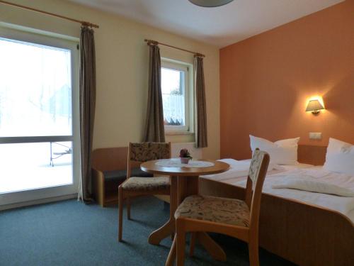FrauensteinにあるGasthof zum Fürstenthalのベッド、テーブル、椅子が備わるホテルルームです。