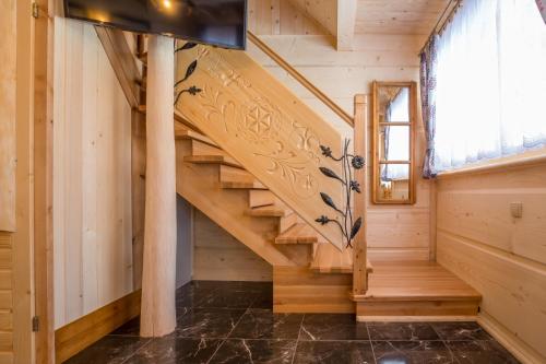 a wooden staircase in a log cabin with a window at Domki u Magdy in Zakopane