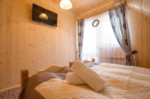 a bedroom with a large bed with a window at Domki u Magdy in Zakopane