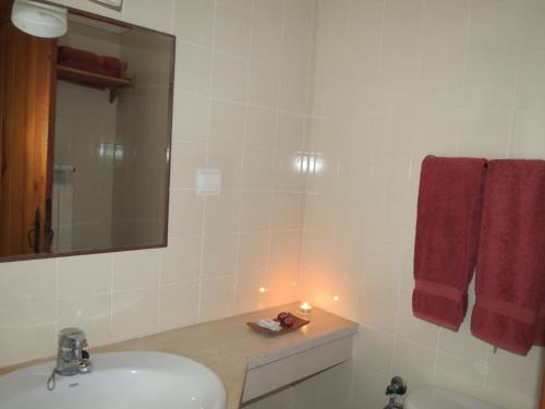 a bathroom with a sink and a mirror and red towels at Amieira Agroturismo in Odemira