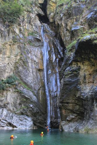 people in the water in front of a waterfall at Agriturismo al Marter in Ledro