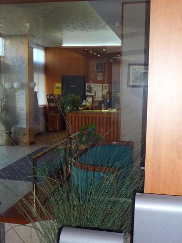 a reflection of a lobby with a person in the mirror at Hotel Cristallo in Udine