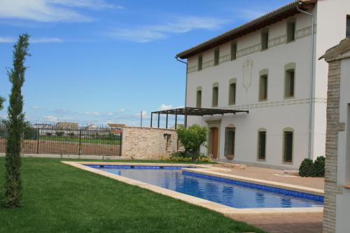 a swimming pool in a yard next to a building at La Mozaira in Alboraya