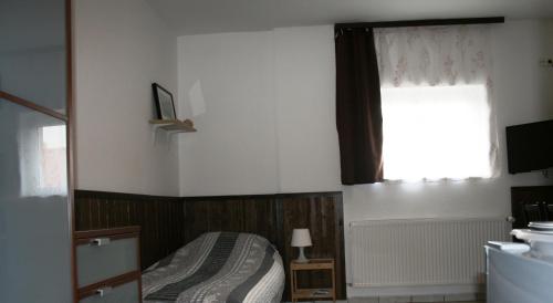 a bedroom with a bed and a window at Fontana Vendégház in Tát