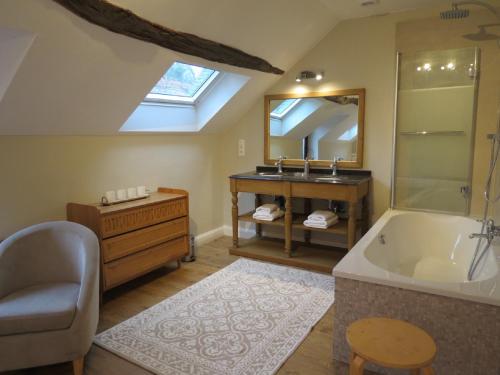uma casa de banho com uma banheira, um lavatório e um espelho. em Gîte du Châtelet em Villers-la-Ville