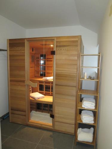 a room with a closet with wooden doors and towels at Gîte incontournable avec sauna et piscine dans un petit paradis du Barbant wallon in Villers-la-Ville