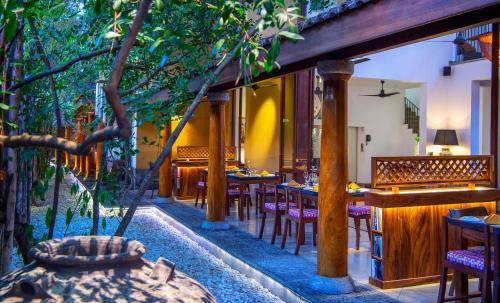 a restaurant with tables and chairs in a garden at Zylan Colombo in Colombo