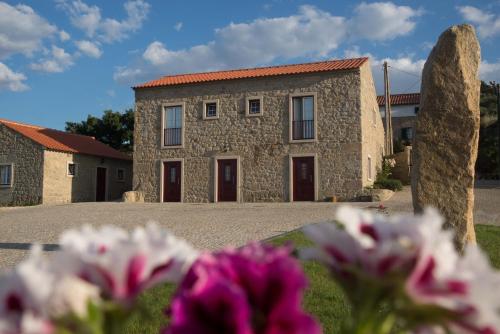 モンサントにあるQuinta da Pedra Grandeの花の前の石造りの家