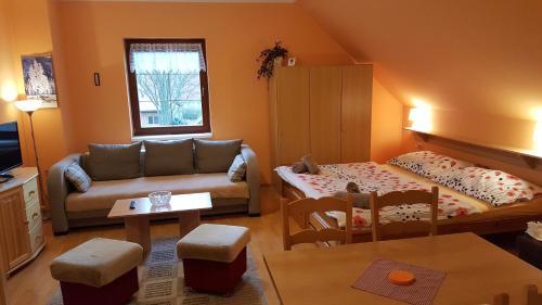 ein Wohnzimmer mit einem Sofa und einem Tisch in der Unterkunft Penzion Otmarka in Těchonín