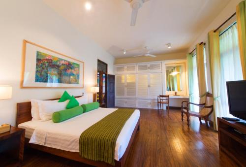 a bedroom with a large bed and a television at Zylan Colombo in Colombo