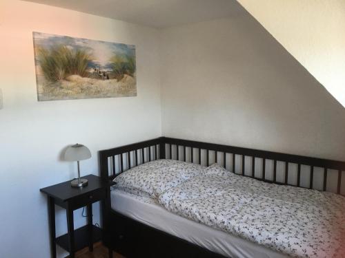 ヴィルヘルムスハーフェンにあるFerien mal andersのベッドルーム1室(ベッド1台付)が備わります。壁には絵画が飾られています。