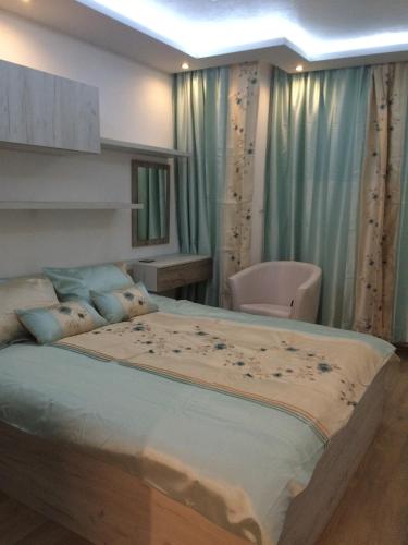 a bedroom with a large bed with blue curtains at Luxury Two Bedroom Flat in Blagoevgrad