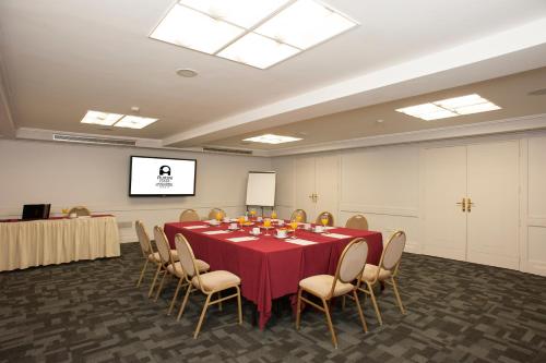 a conference room with a table and chairs and a screen at Austral Express in Comodoro Rivadavia