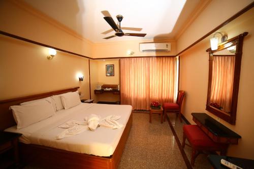 a hotel room with a bed with a towel on it at Mayura Residency in Guruvāyūr